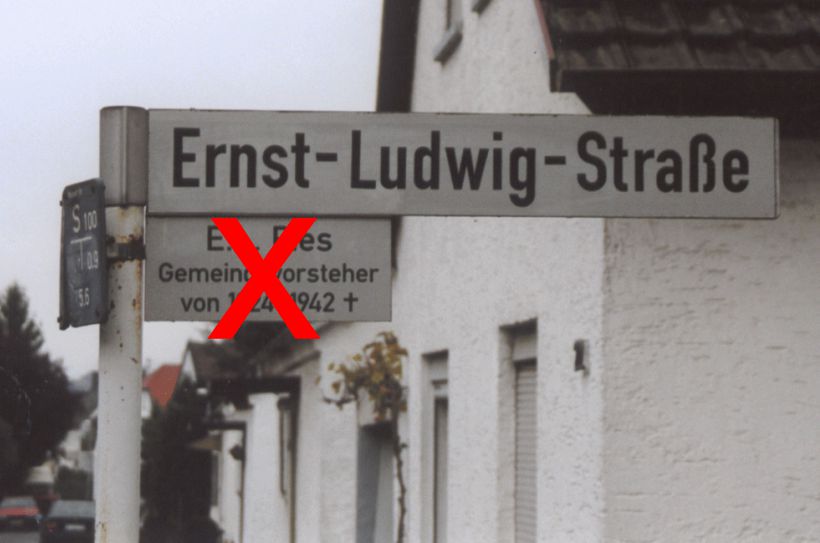Straßenschild Ernst-Ludwig-Straße mit rot durchgestrichenem Zusatzschild, das an den Ortsbürgermeister Ernst Ludwig Pies erinnert